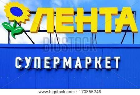 SAINT PETERSBURG RUSSIA - JULY 27 2016: Emblem of the supermarket Lenta against the blue sky. Lenta is one of the largest retail chains in Russia