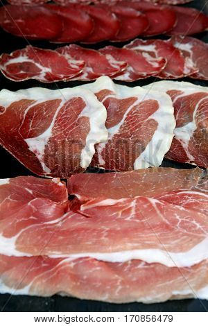 Italian lunch meat prosciutto, culatello and coppa on a cutting board