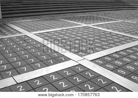 Netherlands -March, 2016 Squares of the same figures on the pavement, numbers on the floor, the numbers in order, paving tiles on the floor in figures, against the background of the stairs