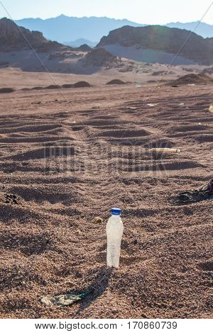 mpty crumpled plastic bottles of water abandoned on the desert.