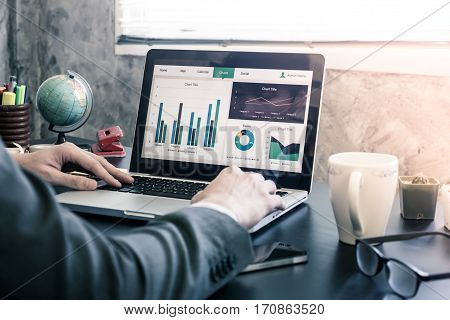 Businessman analyzing investment charts on the office desk.