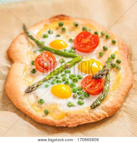 Spring pizza with vegetables and quail eggs