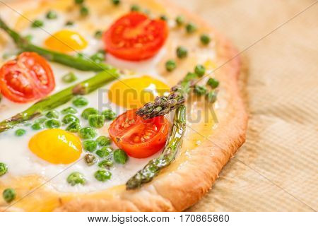 Spring pizza with vegetables and quail eggs