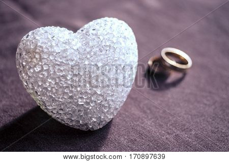 Love, Wedding And Valentine`s Day Concept. Beautiful Golden Wedding Rings And Glass Heart Selective