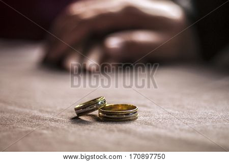 Love, Valentine`s Day And Wedding Concept. Two Wedding Rings With Man And Woman Hands Blurred In The