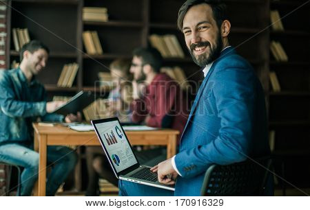 accountant works with financial charts on the laptop in the office on the background of a successful business team