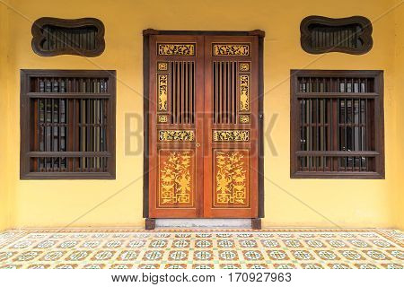 Peranakan typical style windows and ornate entrance doors an floor tiles in Penang Malaysia