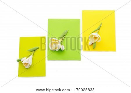 Closeup shot of three small yellow envelopes decorated with art clay tulips. Handmade paper work. Copy space. Isolated over white background.