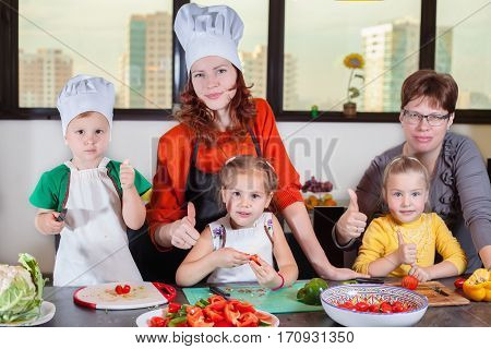 Three cute kids with mom making fruit salad in the kitchen. Healthy eating
