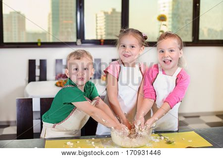 Three Lovely Children Preparing A Cake