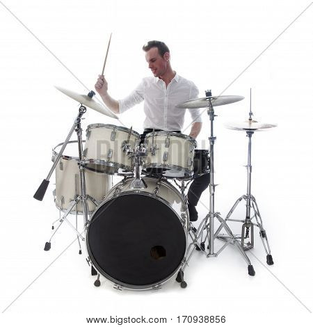 white drummer behind drum set wears white shirt and plays the drums in studio smiling