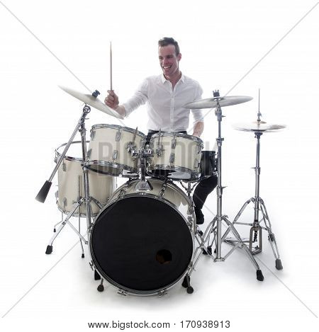 white drummer behind drum set wears white shirt and plays the drums in studio smiling