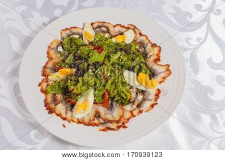 Salad with eel and vegetables. Very tasty food on a light background.