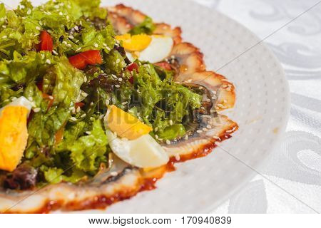 Salad with eel and vegetables. Very tasty food on a light background.