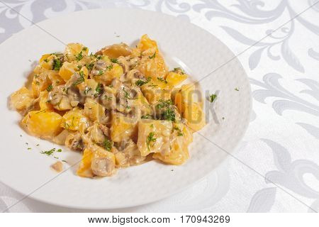 Fried potatoes with herbs. Very tasty food on a light background.