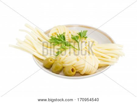 Two portions of the mozzarella cheese in the form of strings twisted in a shape of a plait several green olives and twig of parsley on the saucer on a light background