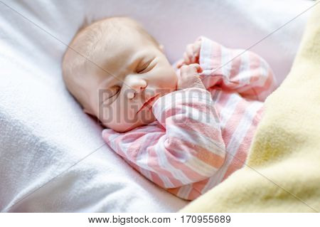 Cute adorable newborn baby sleeping in white bed. New born child, little girl laying in bed. Family, new life, childhood, beginning concept.