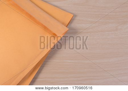 Used Yellow Blank Envelope With Transparent Bubble Wrap Or Packaging Shockproof On Wooden Table.