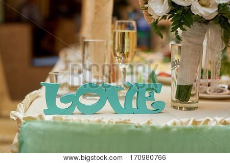 wooden letters love on wedding table bride and groom.