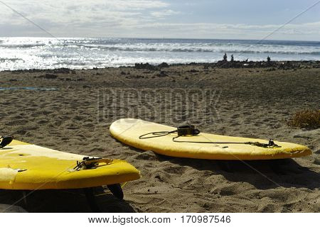 Surf school - several surfboarding students headed into an ocean swell on Tenerife Spain
