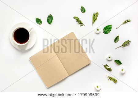 Froral flat lay with cup of coffee and craft notepaper on white background top view mockup