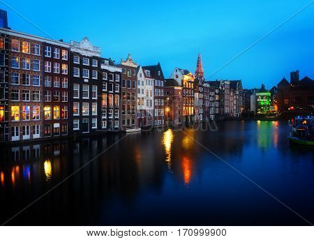 Houses over canal with mirror reflections at blue night, Amstardam, Netherlands, retro toned