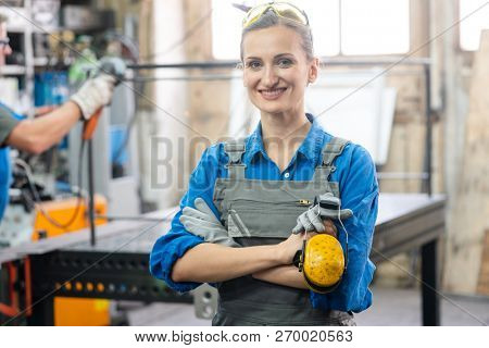 Workers in a metal workshop, man and woman