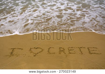 Love Crete Words On Sand Beach Texture With Sea Wave On Background. Summer Concept
