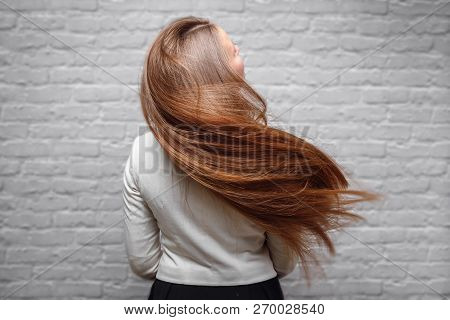 Portrait Of Beautiful Young Brunette Woman With Long Straight Loss Hair In Flight Air.