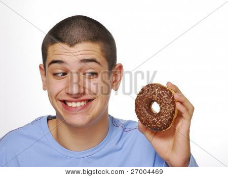 Kleine Junge holding und Essen ein Schokoladen Donuts auf weißem Hintergrund.