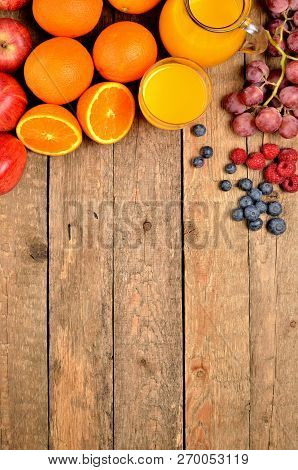 Orange Juice, Fresh Oranges, Apples, Grapes, Raspberries And Blueberries On A Wooden Table - Fruit B