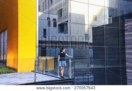 A Chinese Woman Wearing A Skirt Looking Out From A Balcony At A Mall In Shenzhen China.