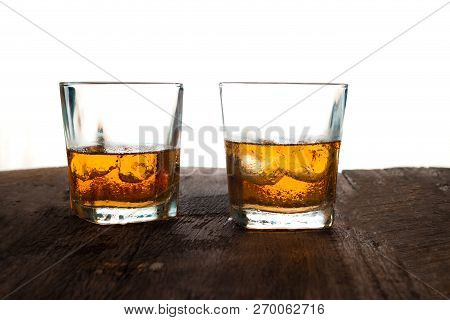 Glass Of Alcohol Scotch Whiskey With Ice On Wooden Table And White Background