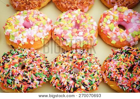 Donuts Background / Set Of Various Colorful Donuts Top View On Tray - Delicious Sweet Donut With Spr