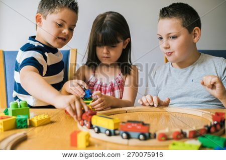 Siblings playing with blocks, trains and cars