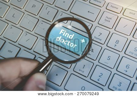 Medicine Concept: Enter Button With Words Find Doctor Viewed Through Loupe On Keyboard Background. P