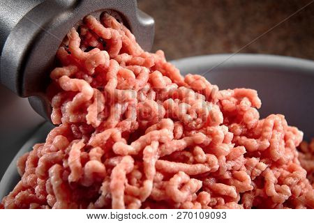 Minced Meat Coming Out From Modern Electric Grinder Close-up. Healthy Fresh Homemade Minced Meat. Pl