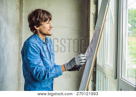 Man In A Blue Shirt Does Window Installation