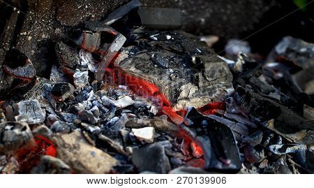 Burning Coals In The Barbecue On A Blurred Background, The Texture Of The Flame