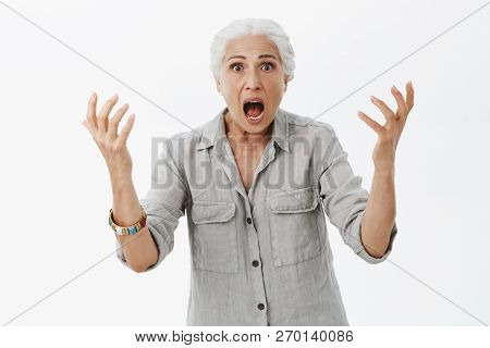Waist-up Shot Of Excited And Shocked Confused Pissed Elderly Mother Shaking With Raised Arms Opening