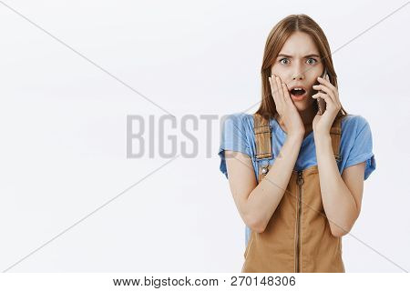 Woman Receiving Phone Call From Friend Being Shocked And Stunned With Conversation Holding Cellhone 