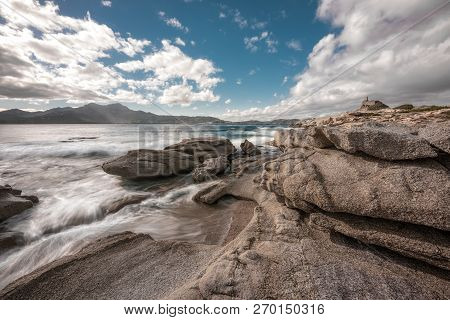 Long Exposure Image Of Waves Washing Onto Rocks On The Coast By The Genoese Tower At Punta Caldanu N