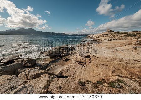 Waves Washing Onto Rocks By The Genoese Tower At Punta Caldanu Near Lumio In The Balagne Region Of C