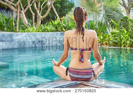 Sporty Slim Woman Meditaing After Swimming In Pool, View From The Back