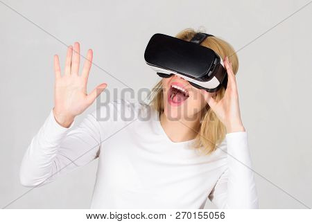 Woman Wearing Virtual Reality Goggles In Grey Background. Woman Using Virtual Reality Headset. Confi