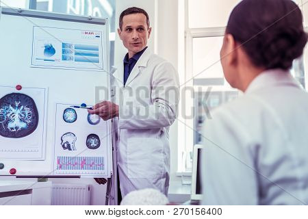 Handsome Doctor Standing Near Board For Presentations