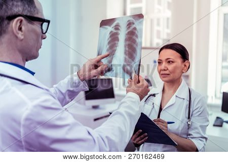 Concentrated International Doctor Working With Her Partner