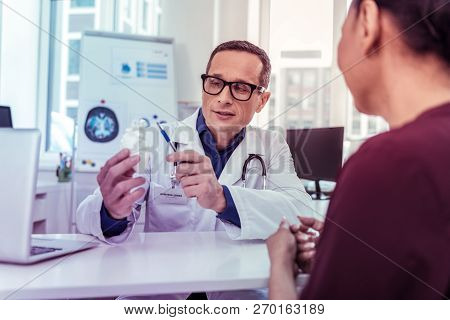 Attentive Brunette Man Pointing At Artificial Heart