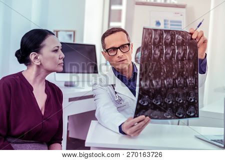 Competent Young Medical Worker Demonstrating X-ray Photo