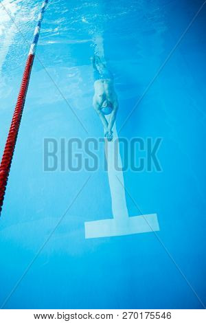 Photo on top of sportsman swimming on back of indoor pool